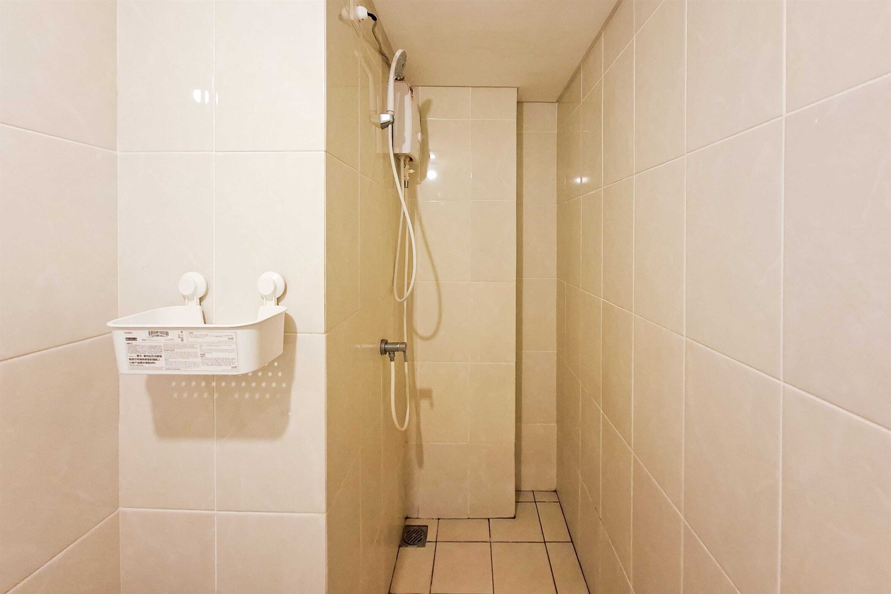 Ein kleines Badezimmer mit gefliesten Wänden, einer weißen Waschbecken und einem Seifenspender an der Wand.