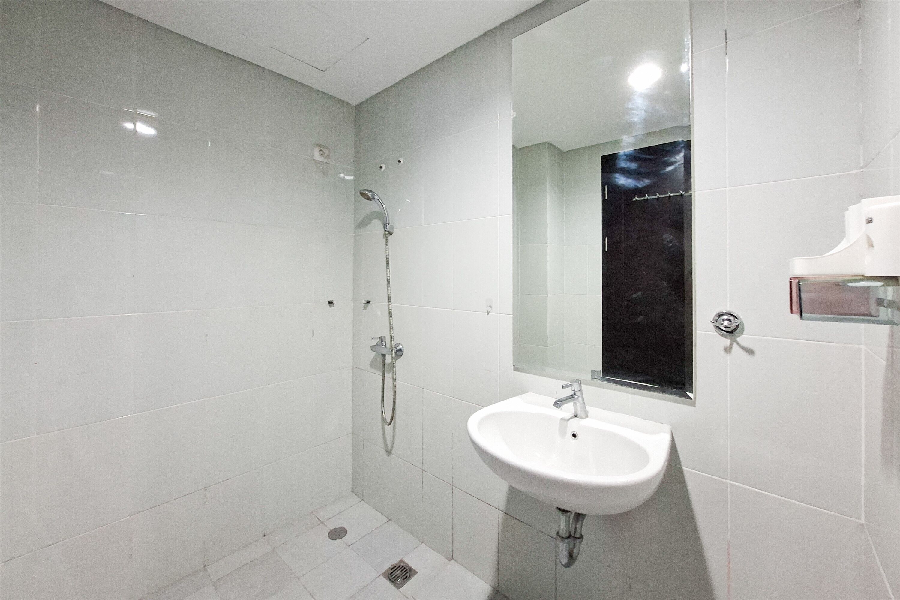 Ein modernes Badezimmer mit einem weißen Waschbecken, einem Spiegel und einer Dusche.