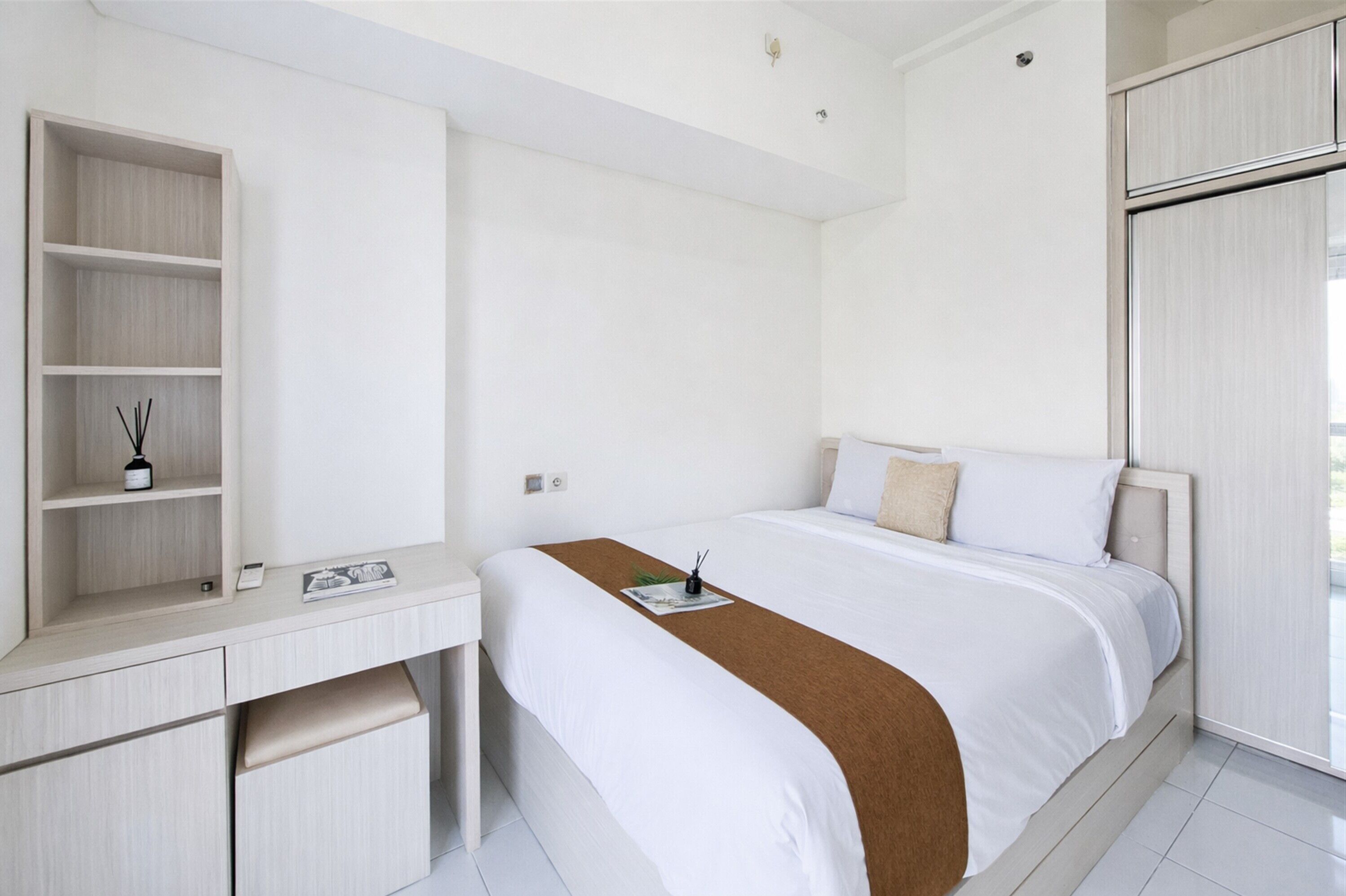Une chambre d’hôtel moderne équipée d’un lit, d’un bureau et d’une armoire.