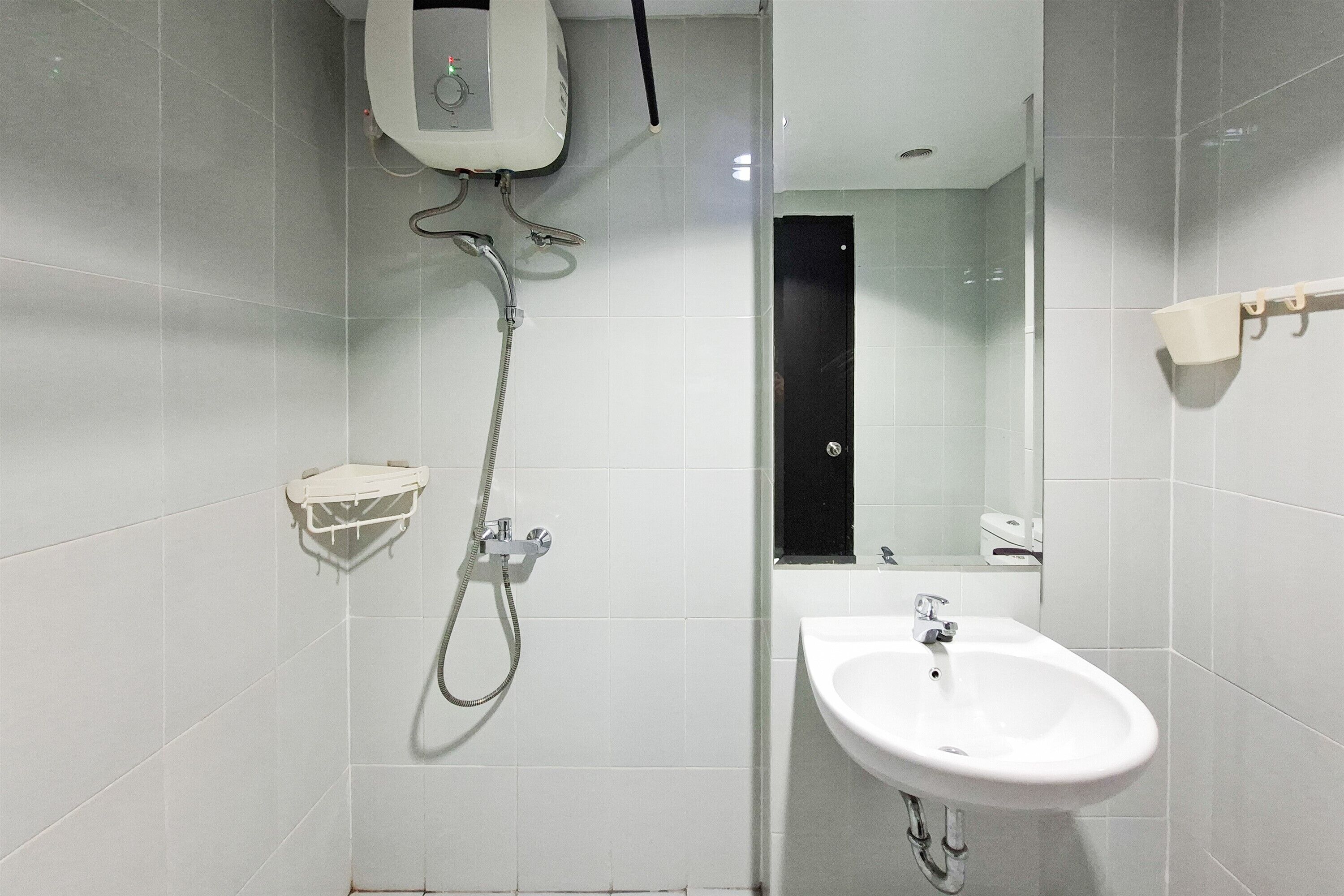 Une salle de bain avec une douche, un lavabo et un miroir.