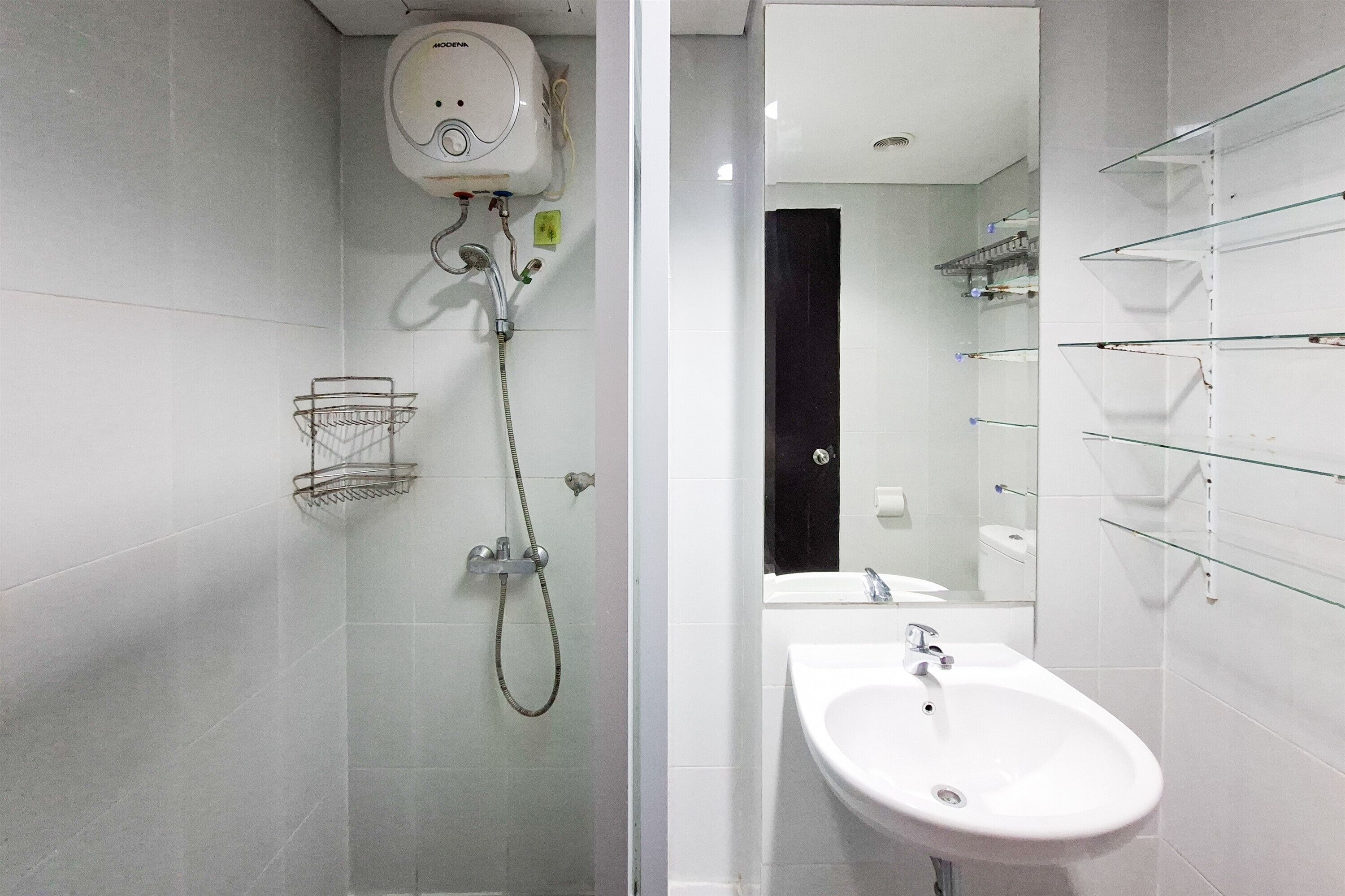 A modern bathroom with a glass shower enclosure, a white sink, and a mirror.