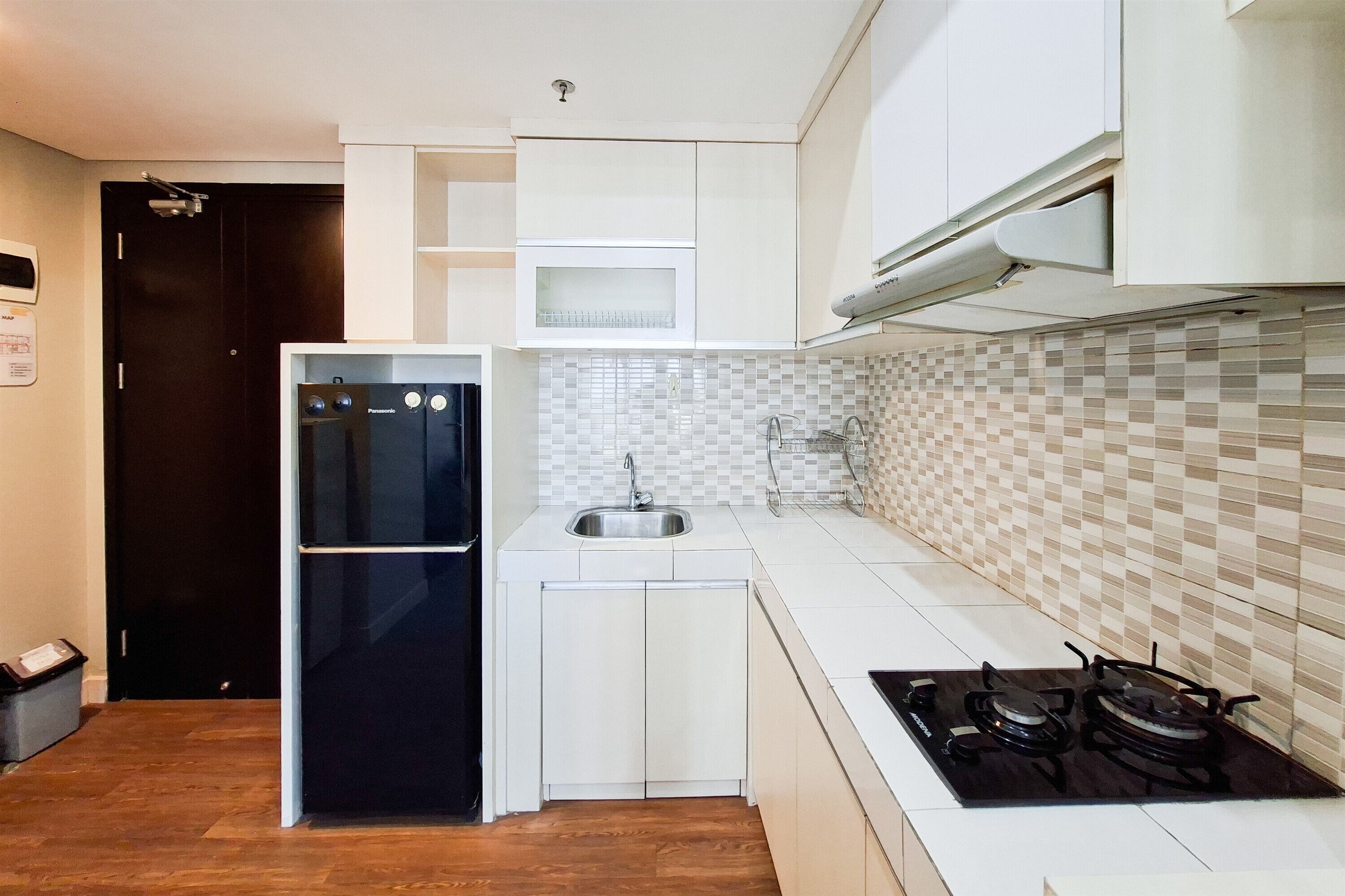 A compact kitchen with a refrigerator, sink, and stove.