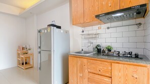 Eine moderne Küche mit Holzschränken, einem Edelstahlkühlschrank, einer Spüle und einem Herd.
