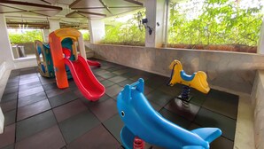 A children's play area with a slide, a climbing structure, and a rocking horse. - Warm 2Br For 3 Pax At Bassura City Apartment Near Shopping Center (Jakarta)