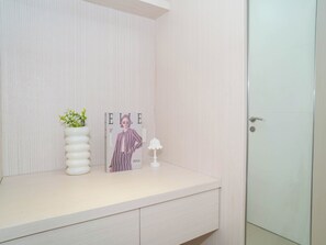 En badeværelsesvask med et stribet magasin, en potteplante og en lampe.