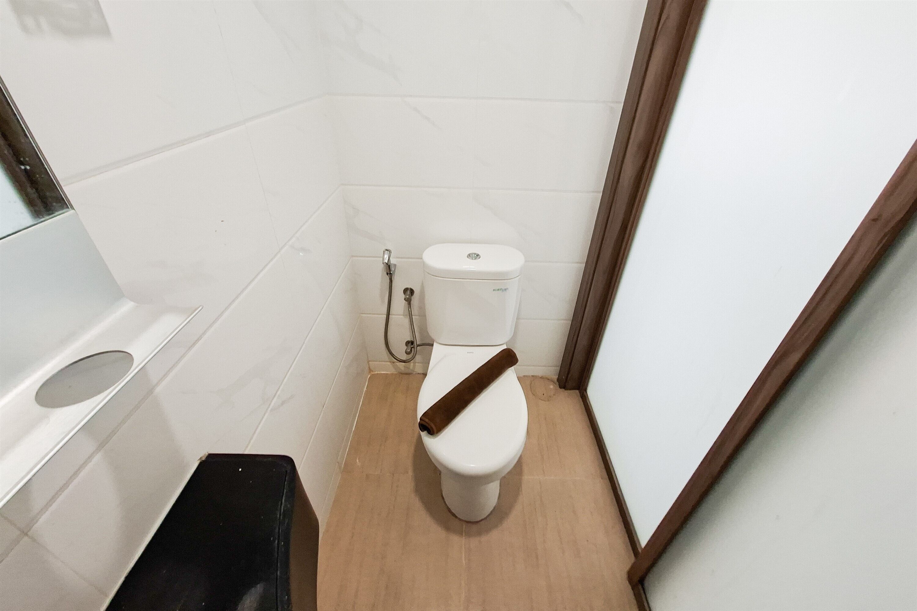 A small bathroom with a toilet, a shower, and a sink.