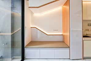 Una cocina moderna con un banco empotrado, un revestimiento de pared de madera y un separador de vidrio.