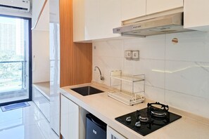 Una cocina moderna con un lavamanos doble, una estufa y una ventana con vistas a edificios.