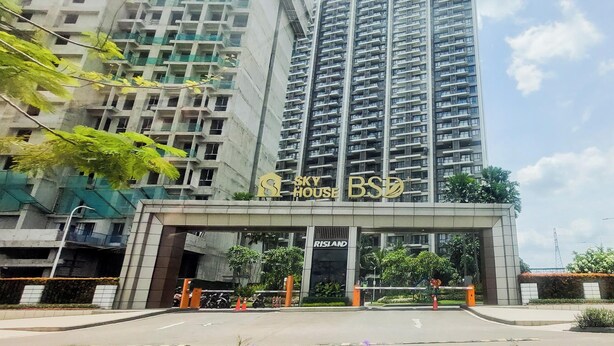 A high-rise building with a prominent entrance labeled 'Sky House BSB' and 'RISLAND' on the facade. - Bright And Homey Studio Room At Apartment Sky House Bsd (Balaraja)
