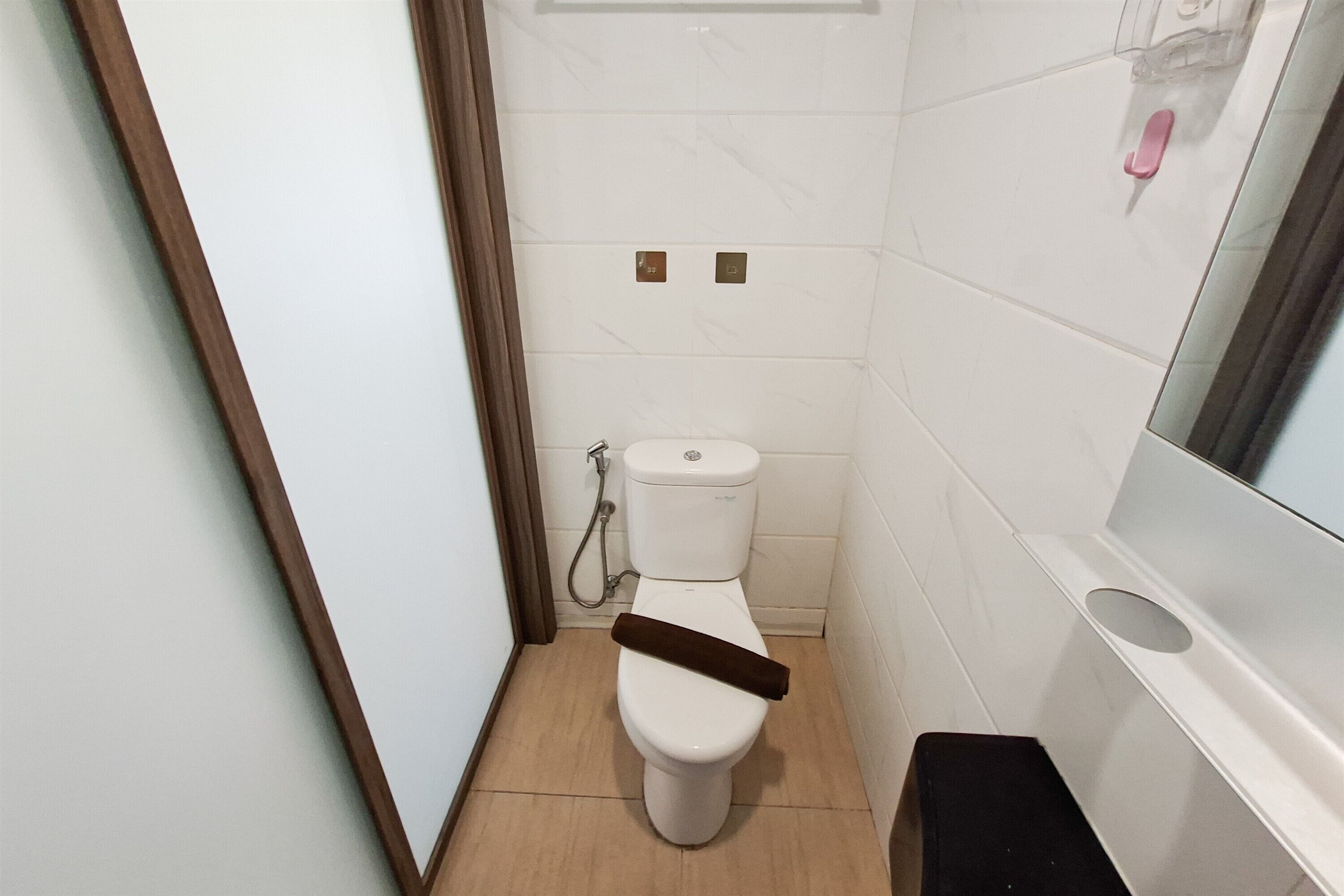 A small bathroom with a toilet, a shower, and a mirror.