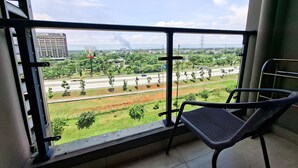 Ein Balkon mit Blick auf eine Autobahn, Grünflächen und ein Gebäude in der Ferne.