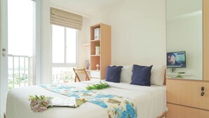 A bedroom with a bed, a TV, a bookshelf, and a balcony. - Cozy White Studio For 2 Pax At Tokyo Riverside Pik 2 Apartment (Teluknaga)