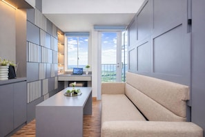 A modern kitchen with a central island, a built-in seating area, and a view of the outdoors. - Studio Chic Areum Residence At Tokyo Riverside (Teluknaga)