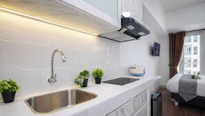 Ett modernt kök med en diskho i rostfritt stål, en inbyggd köksfläkt och en brödrost på bänkskivan.