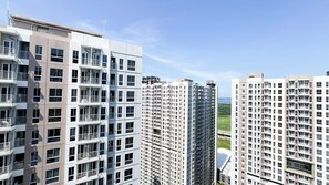 A high-rise residential building with multiple balconies, a flat roof, and a clear view of the sea in the background. - Best Choice Studio Near Nice At Tokyo Riverside Pik 2 Apartment (Teluknaga)