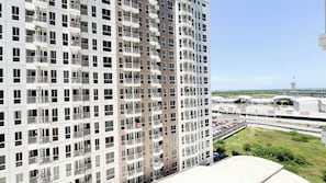 A high-rise building with multiple balconies and a parking area in the background. - Stylish And Functional 2Br Apartment At Tokyo Riverside Pik 2 (Teluknaga)