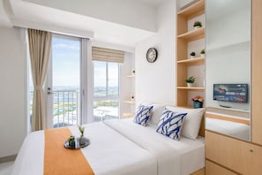 A hotel room with a bed, a TV, a clock, and a balcony with a view. - Practical Studio For 2 Pax At Tokyo Riverside Pik 2 Apartment Near Nice (Teluknaga)