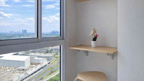 A room with a large window, a potted orchid, and wooden shelves. - Practical Studio For 2 Pax At Tokyo Riverside Pik 2 Apartment Near Nice (Teluknaga)