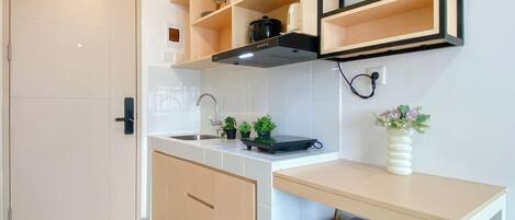 A modern kitchen with a built-in sink, wooden cabinets, a countertop, and a black range hood.