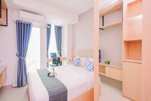 A hotel room with a bed, a desk, a chair, a TV, and a wardrobe. - Comfy Studio For 2 Pax At B Residence Grogol (Jakarta)