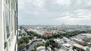 A cityscape with a river, buildings, and a clear sky. - Comfy Studio For 2 Pax At B Residence Grogol (Jakarta)