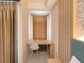 Ein Zimmer mit Schreibtisch, Stuhl und einem Bett.