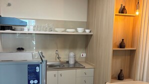 A modern kitchen with a built-in refrigerator, a sink, and a round dining table. - Ravello Residential AP08 Foz do Iguaçu (Foz do Iguaçu)