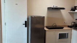 A modern kitchen with a stainless steel refrigerator, a built-in oven, a microwave, and a coffee maker on the countertop. - Ravello Residential AP08 Foz do Iguaçu (Foz do Iguaçu)