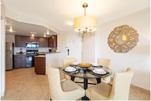 A modern kitchen with dark wooden cabinets, a stainless steel refrigerator, and a built-in oven.