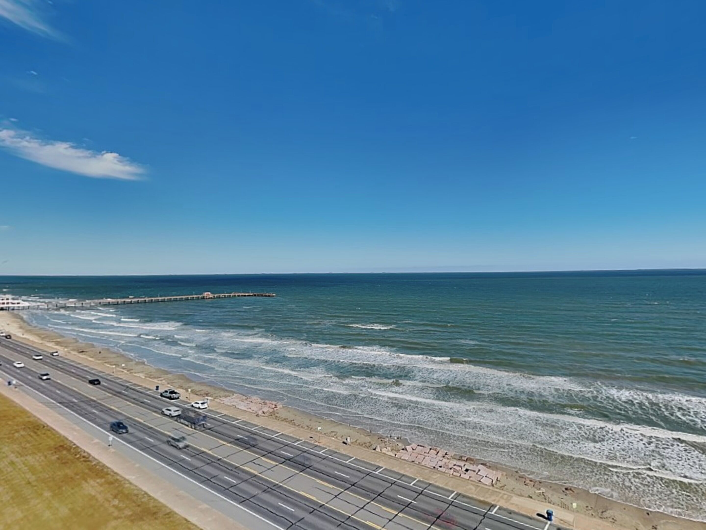 Una carretera costera con una playa y el océano a la derecha.