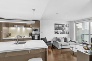 Eine moderne Küche mit Kochinsel, einem Essbereich mit Sofa und Blick auf die Stadt.