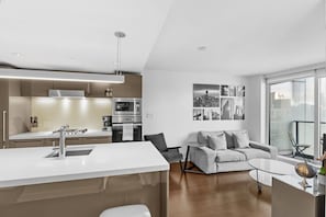 Eine moderne Küche mit Kochinsel, einem Essbereich mit Sofa und Blick auf die Stadt.