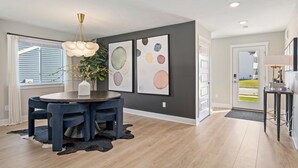 A modern dining area with a round table, chairs, and a hanging light fixture. - Private Pool, Infared Sauna, Full Gym, Hot Tub, Sleeps 16 (Grandville)