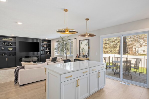 A modern kitchen with a large island, built-in appliances, and a dining area with a view. - Private Pool, Infared Sauna, Full Gym, Hot Tub, Sleeps 16 (Grandville)