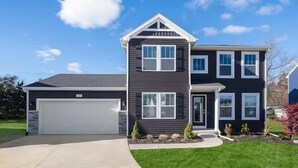 A two-story house with a garage, a front porch, and a well-maintained lawn. - Private Pool, Infared Sauna, Full Gym, Hot Tub, Sleeps 16 (Grandville)