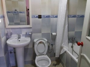 Un baño con lavamanos, inodoro y bañera.