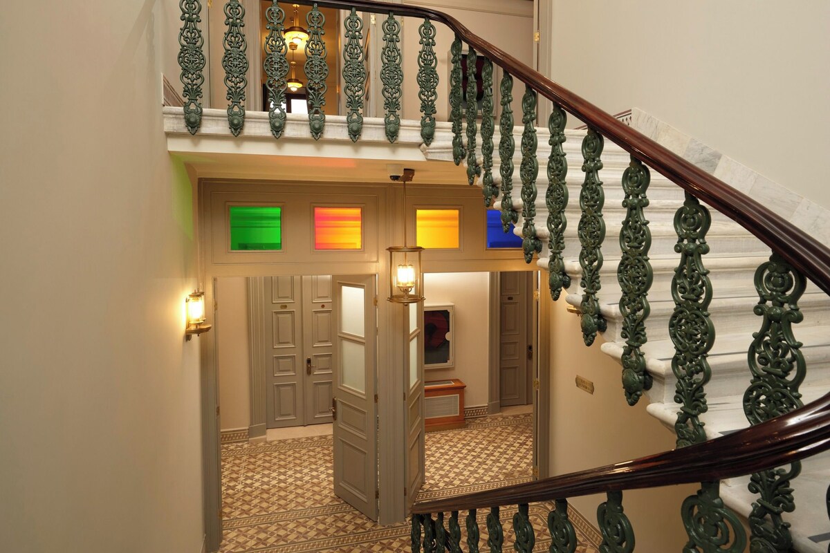 A multi-level staircase with ornate railings and a patterned carpet.
