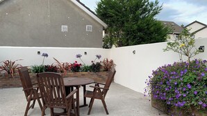 An outdoor patio with a table and chairs, surrounded by a brick wall and various plants. - Galway City Stayin quant neighbourhood (Galway)