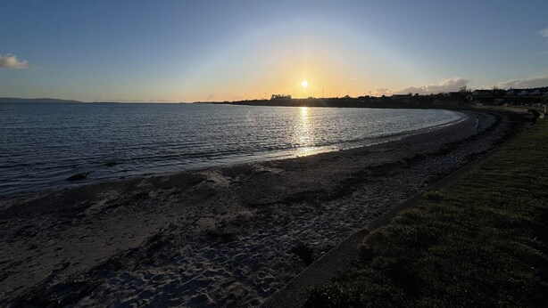 A beach with a curved shoreline, a clear sky, and a sunset. - Galway City Stayin quant neighbourhood (Galway)