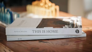Un libro dal titolo 'THIS IS HOME' di Natalie Walton su una superficie in legno.