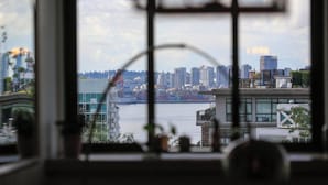 Vista attraverso una finestra su un panorama urbano con edifici, un corso d'acqua e un ponte.