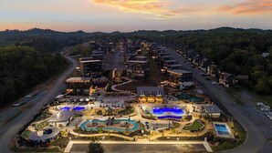 An aerial view of a resort with multiple buildings, a swimming pool, and landscaped areas. - Cabin near Dollywood w/ pool & hot tub (Sevierville)