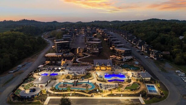 Oversigtsbillede af et resort med flere bygninger, en swimmingpool og anlagte områder.
