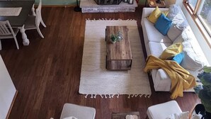 A living room with a fireplace, a sofa, a coffee table, and a dining area with chairs. - Arrowhead Community Hot Tub Firepit Game Rm Movie Rm Fireplace Walk 2 Pool, Lake (Pocono Lake)