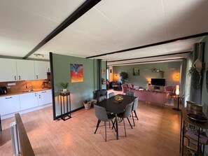 A modern interior with a dining area, kitchen, and living space. - Maison Marly | Jacuzzi & Castle View by Dordogne (Castelnaud-la-Chapelle)