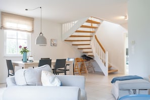 Un intérieur moderne comprenant un escalier, un coin repas et un espace détente.