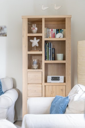 Une bibliothèque en bois agrémentée d’objets décoratifs, de livres et d’une radio.