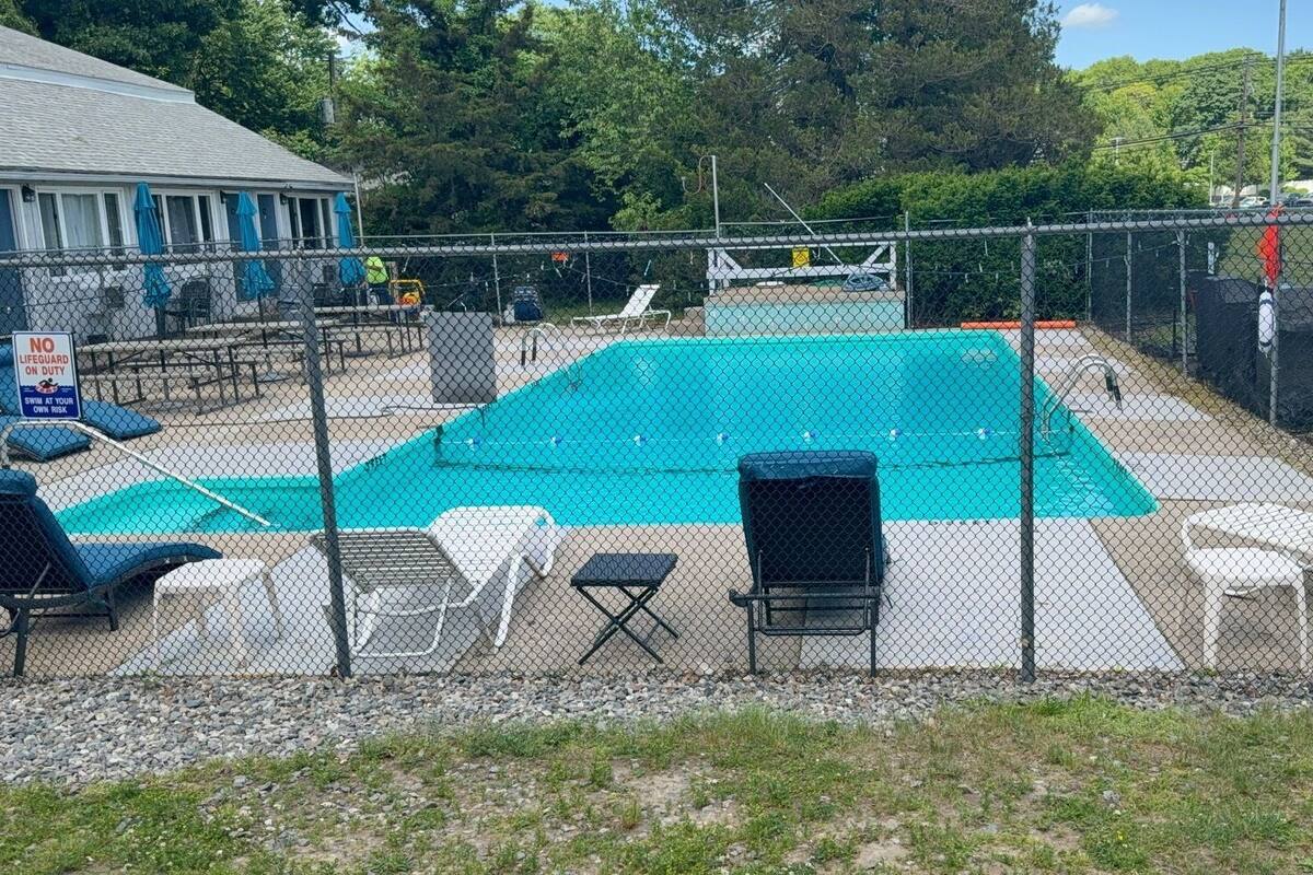 A fenced swimming pool area with lounge chairs and a lifeguard station.