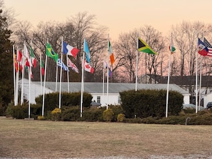A flag display with multiple national flags in front of a building. - Pineapple Inn (North Attleboro)