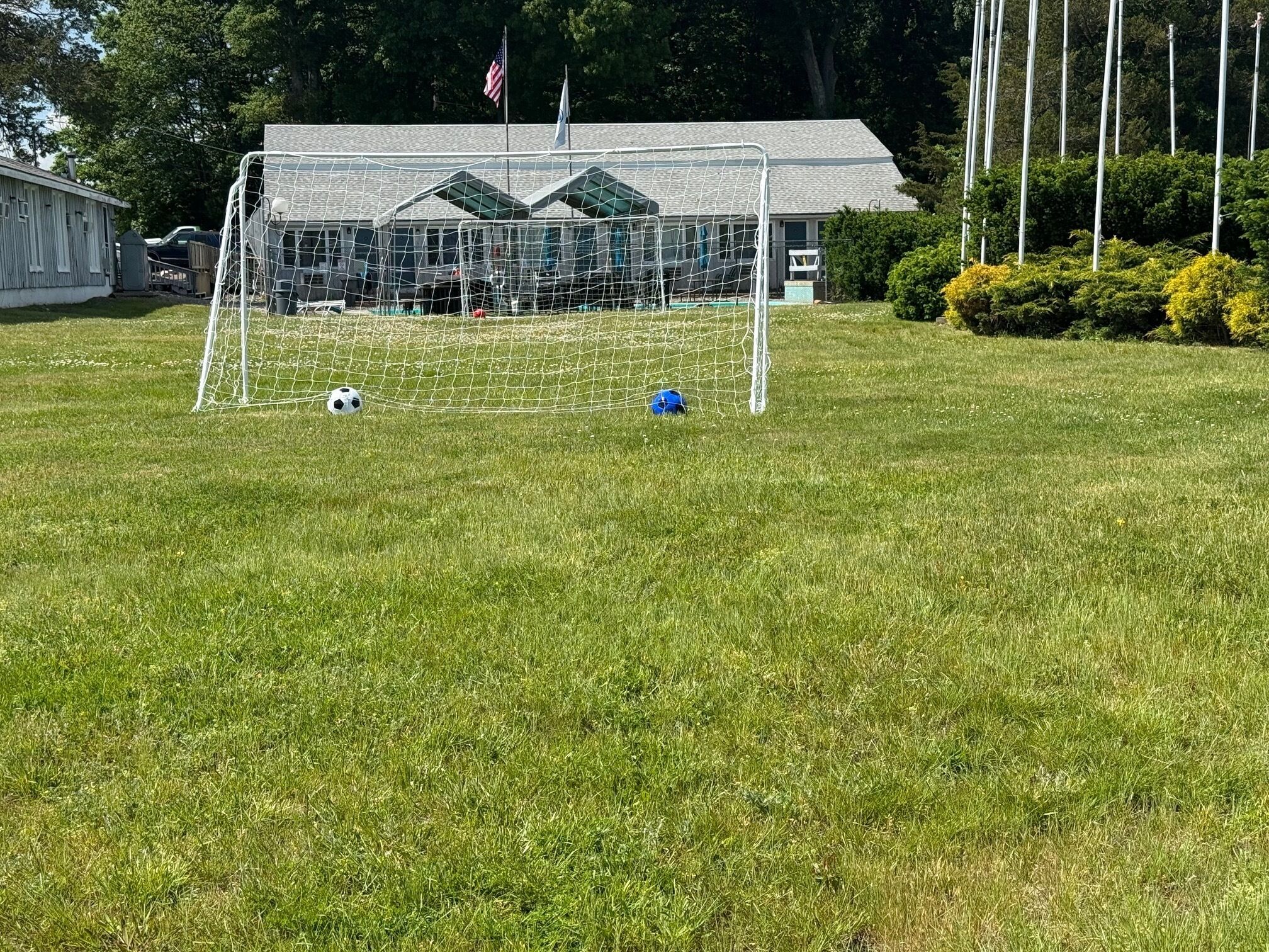 Una portería de fútbol en un campo de césped con un edificio al fondo.